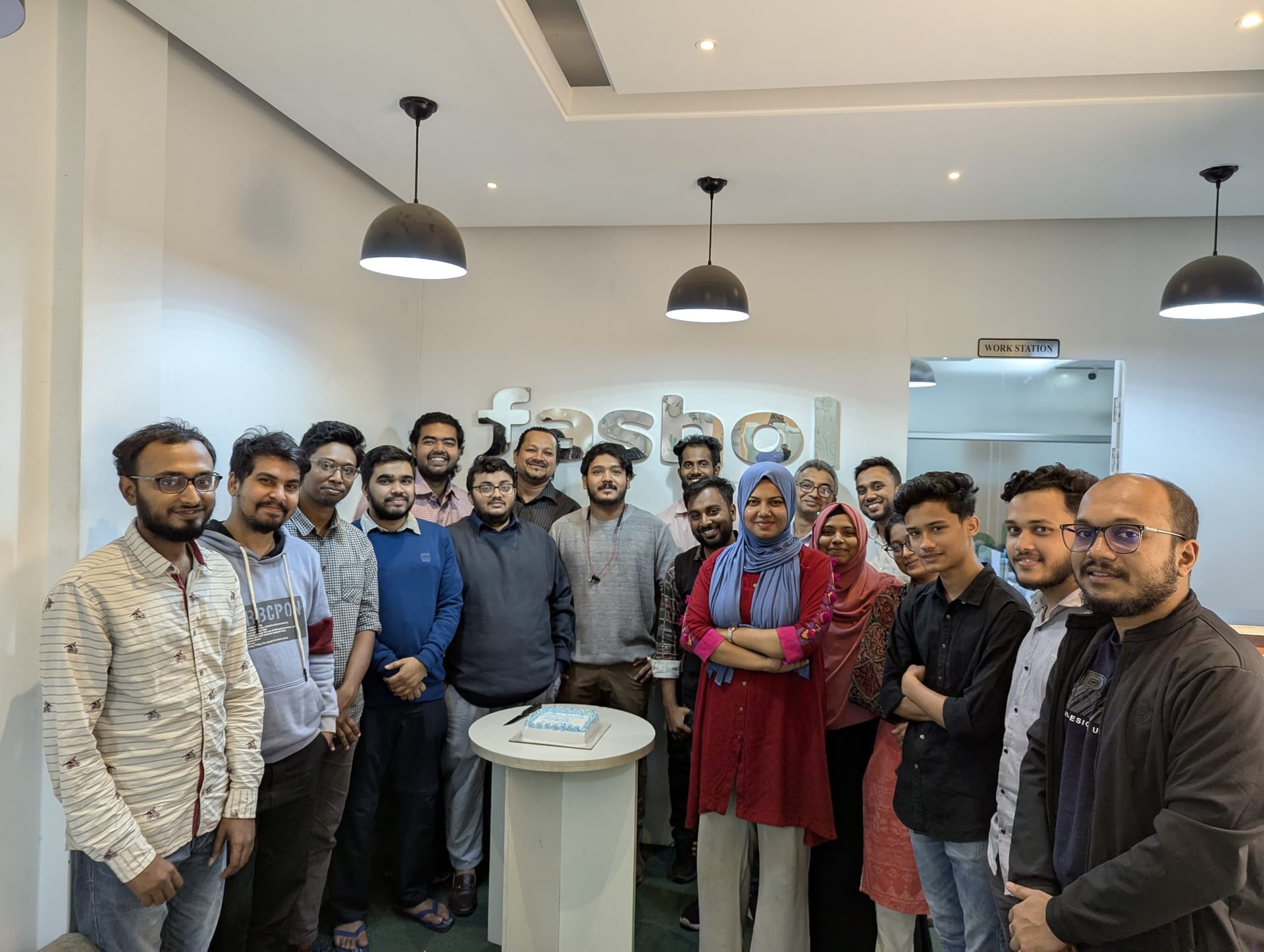 A Fashol hub team sits around a long table for a debrief at end of day.